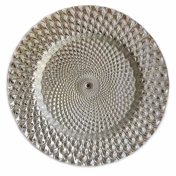 A circular metallic charger plate featuring a concentric design made from numerous small, shiny, textured teardrop elements, creating a radiating pattern.