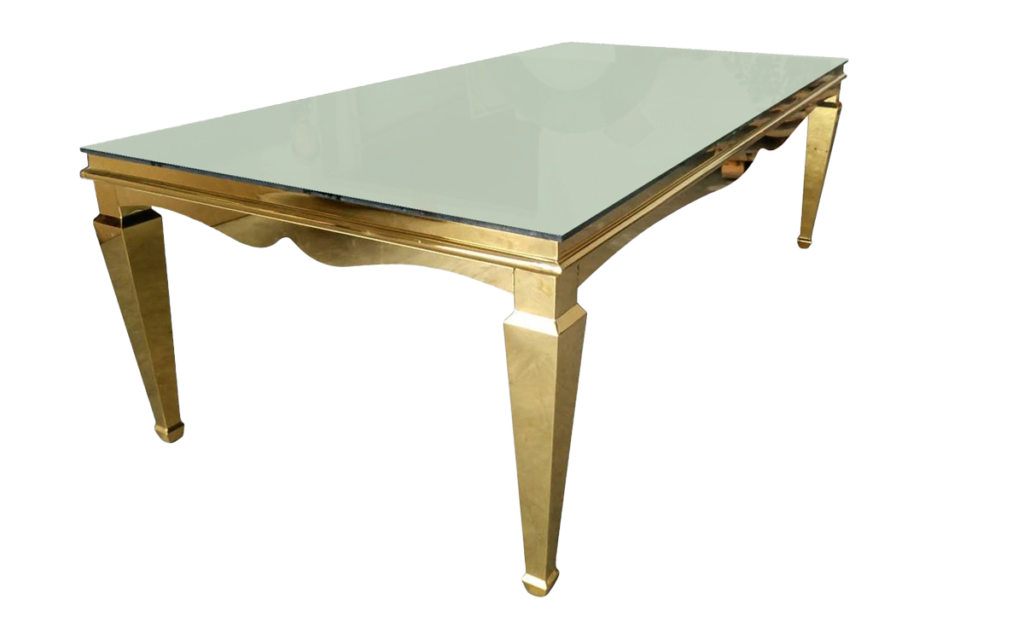 A modern rectangular dining table with a clear glass top and golden metallic legs isolated on a white background.
