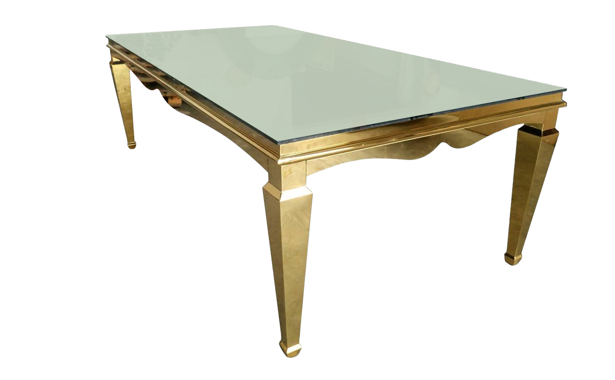 A modern glass-top table with a reflective gold frame and tapered legs, isolated on a white background.